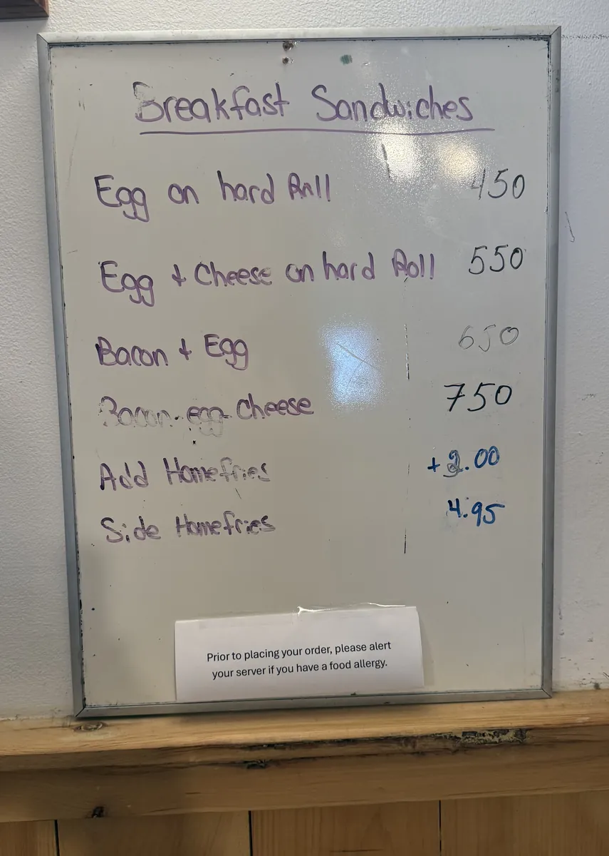 The handwritten breakfast sandwich board by the counter